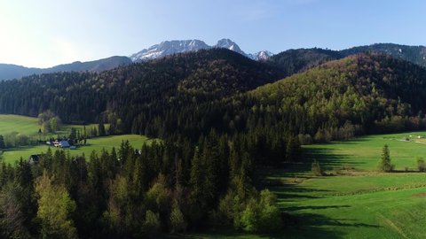 Aerial view of green hills and mountains covered with snow in summer or spring. Giewont mountain massif in the Tatra Mountains of Poland and panorama of Zakopane