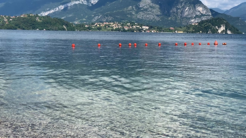 Three swans mother father and little chick son swimming along Lake Como
