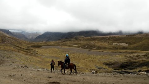 Natives lead horses carrying tourists up mountain at rainbow mountain