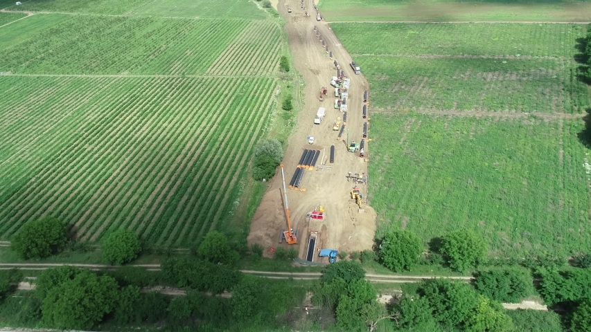 Aerial view of gas and oil pipeline construction. Pipes welded together. Big pipeline is under construction. Royalty-Free Stock Footage #1056110771