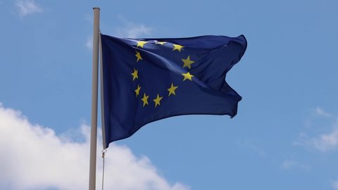 Footage of an EU European flag and flag poole blowing in the wind on a bright sunny summers day taken in the Spanish island of Ibiza