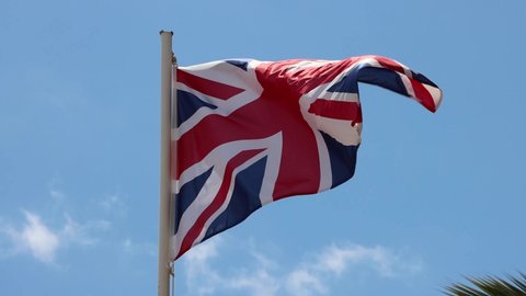 Footage of a British flag blowing in the wind on a bright sunny summers day taken in the Spanish town of Ibiza in Spain