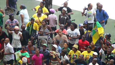 CAPE TOWN, SOUTH AFRICA, CIRCA DEC 2013, African people dancing, turning, clapping, holding ANC flag & Mandela picture at Mandela Memorial event at stadium