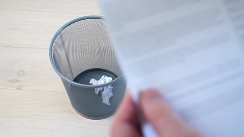Office employee tossing away crumpled paper into trash can