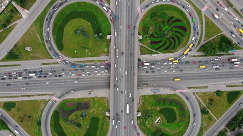 Overhead drone shot of traffic driving over roundabout with highway tunnel underneath, infrastructure and transportation in Kiev, Ukraine
