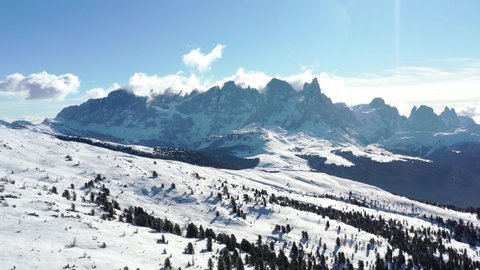 Drone footage aerial in winter snow ski sunny days - Ski Area Alpe Lusia, Moena region, Italian Dolomites. The camera slides down smoothly