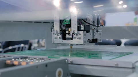 Automated technology, industrial, robotic, electronic, production, manufacturing concept. Assembly of computer circuit board: automatic SMD pick and place machine during work at trade show, exhibition