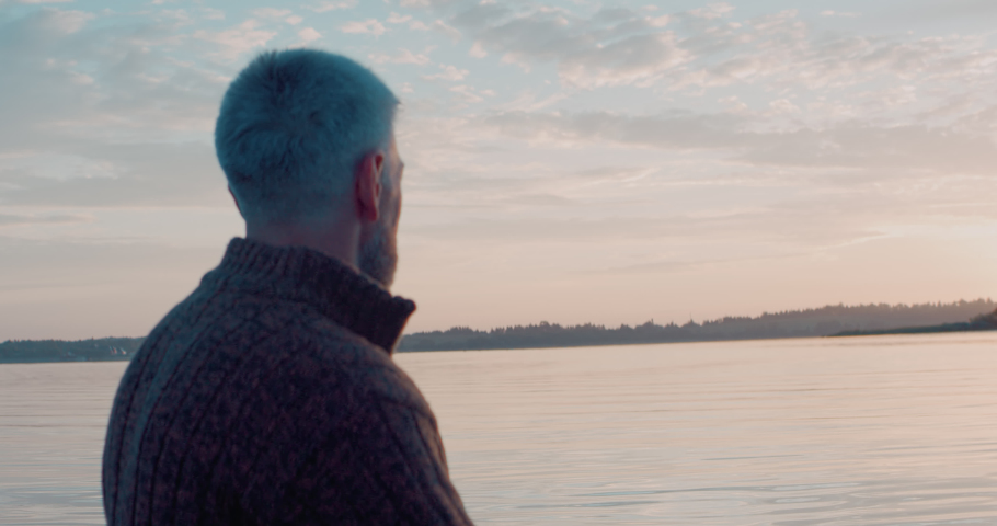 Mid 50s Caucasian male enjoying the sunrise while canoeing on a large lake. Shot on RED cinema camera with 2x anamorphic lens