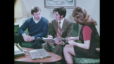 1970s: Paperboy delivers newspaper. Salesman talks to woman. Woman talks to girl scouts. Man walks down sidewalk. Man sits on couch, talks to man and woman.