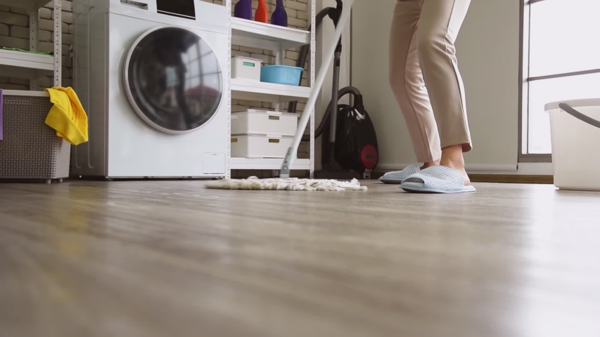 Young Asian woman in casual outfit doing chores housework using dust mop sweeping to clean floor in modern room at home Royalty-Free Stock Footage #1056131396