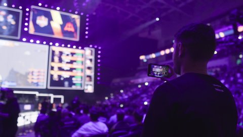 MOSCOW - 14 SEPTEMBER 2019: esports Counter-Strike: Global Offensive event. Flyby around man who taking video on the mobile phone at arena during tournament game.