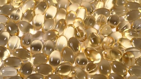 Organic supplements vitamins yellow capsules Omega 3 or D-3 pills, macro shot. Dietary supplement, close up