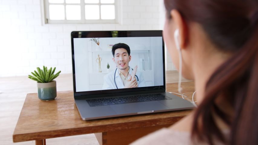 Asian woman talking with doctor via computer laptop virtual video call or video conference at home, telehealth and telemedicine concept | Shutterstock HD Video #1056145400