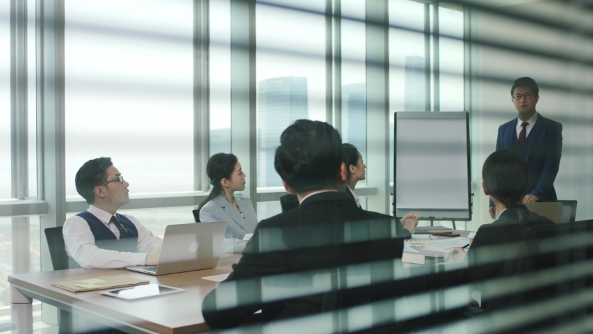 Asian boss delivering a speech during team meeting in modern office | Shutterstock HD Video #1056146492