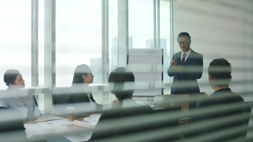 asian boss delivering a speech during team meeting in modern office Royalty-Free Stock Footage #1056146492