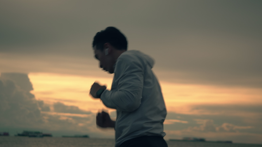 Silhouette of a boxer asian man is practicing boxing workout on the beach during a beautiful sunset in summer. Healthy sports lifestyle concept. | Shutterstock HD Video #1056147011