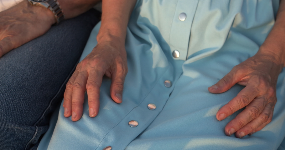 Close-up of the hands of the elderly, the man takes the woman's hand tightly and gently squeezes it, the woman strokes her husband's hand with the other hand. The frame shows love and devotion carried Royalty-Free Stock Footage #1056148709