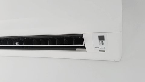 Modern air condition unit on a white wall inside the living room.	
