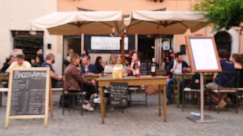 Defocused view of the traditional Italian cafe. Unidentified people eating Italian food and having conversation in an outdoor restaurant in Trastevere district in Rome, Italy. | Shutterstock HD Video #1056158669