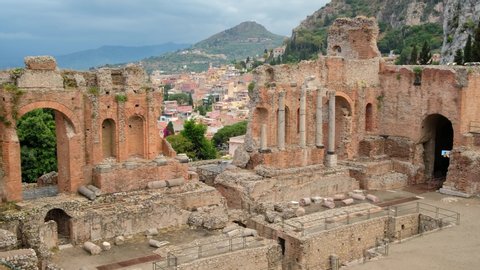 Amphitheatre of Taormina in Siciliy, Italy. Ruins of ancient Greek theatre in Taormina at cloudy day. Slow panning 