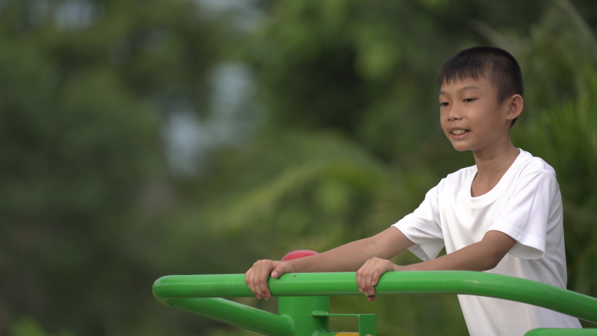 Kids playing and exercing on public outdoor gym park, boy children holding equipment and smile to enjoy play and exercise for good health for outside reaction on blurred background, Asian kids child