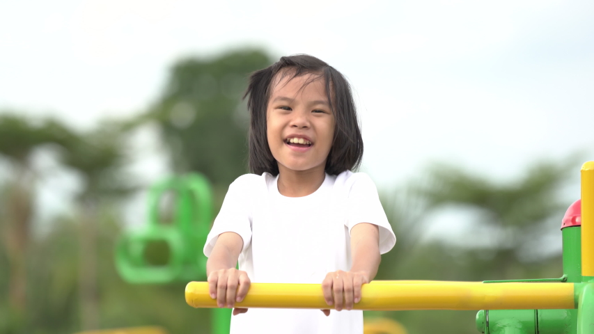Kids playing and exercing on public outdoor gym park, girl children holding equipment and smile to enjoy play and exercise for good health for outside reaction on blurred background, Asian kids child