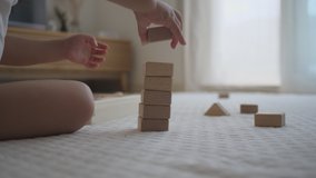 Stacked blocks collapse. 2 years girl building wooden blocks at home. White floor mat. Close Up - Powered by Shutterstock - Get 15% off with code: PIKWIZARD15