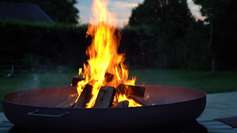 Iron fire pit and burning fire in a garden. 