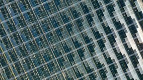 Aerial top view of greenhouse. Bird view with rotation over the glass roof. Indoor farming, heat recovery, power consumption and organic plant protection concept. Background video, copy space - Powered by Shutterstock - Get 15% off with code: PIKWIZARD15