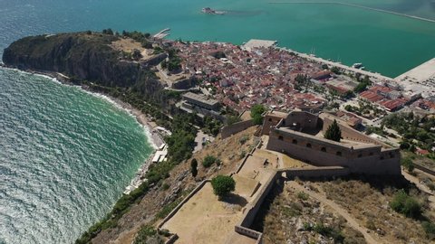 Aerial drone breathtaking view video from medieval Venetian fortress of Palamidi built uphill overlooking Acronafplia castle and historic seaside old town of Nafplio, Argolida, Peloponnese, Greece