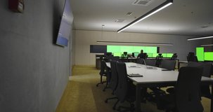 Empty office, desk, and chairs at a main CCTV security data center with green screen and chroma key