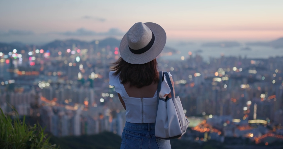 Young woman look at the city in Hong Kong at sunset time