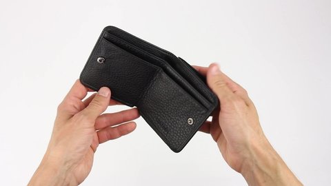human hands holds black leather wallet, open it and search for money, purse is empty, inscription leather, white background