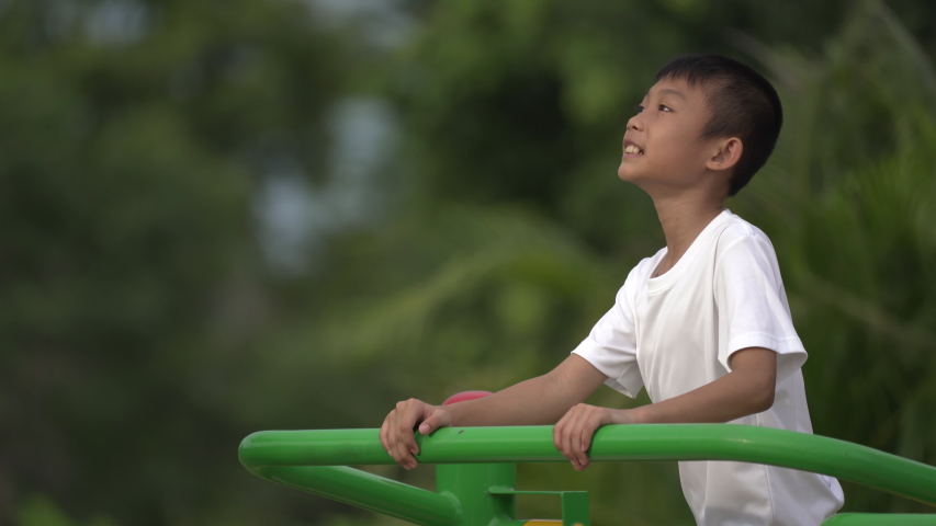 Kids playing and exercing on public outdoor gym park, boy children holding equipment and smile to enjoy play and exercise for good health for outside reaction on blurred background, Asian kids child