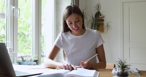 Student girl sitting at desk holds pencil writing essay read textbook, do homework enjoy easy interesting learning process, self-education activity, higher education, gain knowledge, brainwork concept