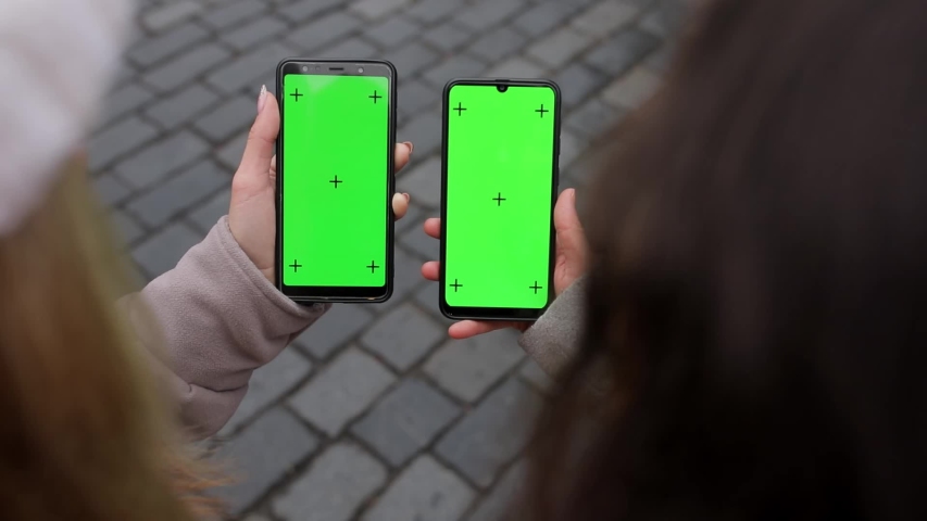 Close up of a two woman's hand holding a mobile telephone with a vertical green screen in street and old town of Prague chroma key smartphone technology cell phone street touch message display hand Royalty-Free Stock Footage #1056193934