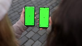 Close up of a two woman's hand holding a mobile telephone with a vertical green screen in street and old town of Prague chroma key smartphone technology cell phone street touch message display hand