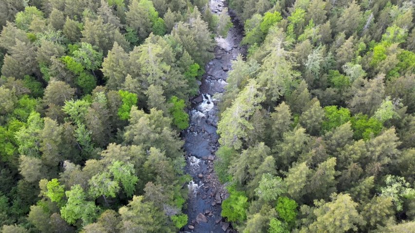 Wells, New York / United States - May 24 2020: Aerial View of mountain creek in Adirondack Region of New York. Top down view moving forward. 