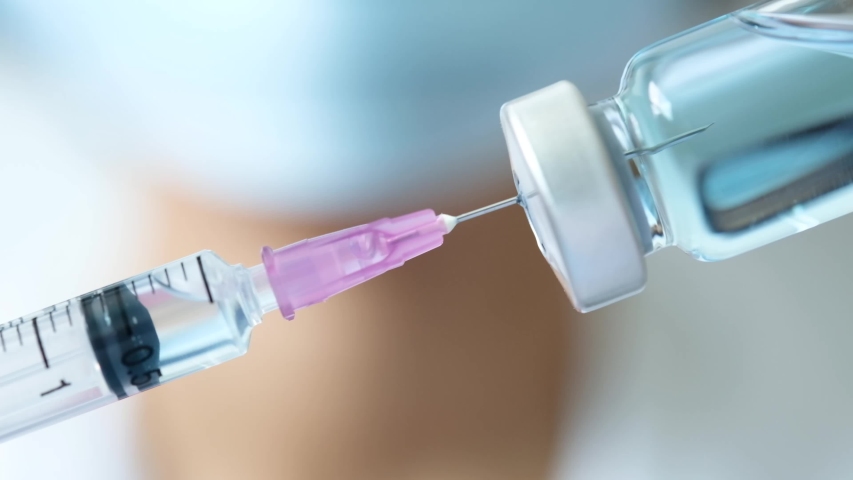 Doctor's hand holds a syringe and a blue vaccine bottle at the hospital. Health and medical concepts. | Shutterstock HD Video #1056197825