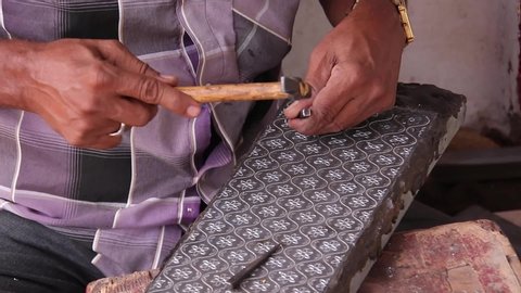Close up footage of a traditional Bidri artisan carving inlay patterns into a zinc plate in Bidar, Karnataka, India