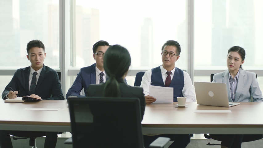 rear view of a young asian business woman being interviewed by a group of human resources executives in conference room of modern corporation Royalty-Free Stock Footage #1056201257