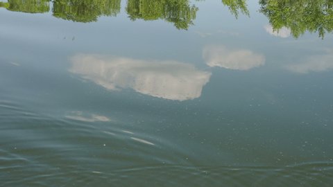 Close-up of the disturbed blue surface of the water. Reflection of the sky and clouds while sailing on a river or lake