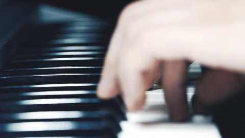 Music performer's hands playing the piano, close up slow motion shot