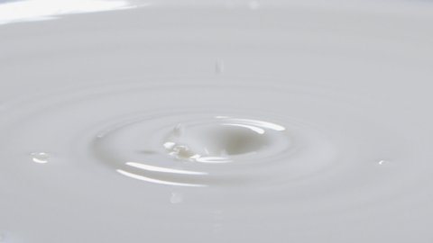 Fresh milk Single Drop Splashing in a Milk Pool. Slow motion. Milk Drop or White Liquid Drop Created Ripple Wave. Milk Drop With Ripples, Slow Motion. 