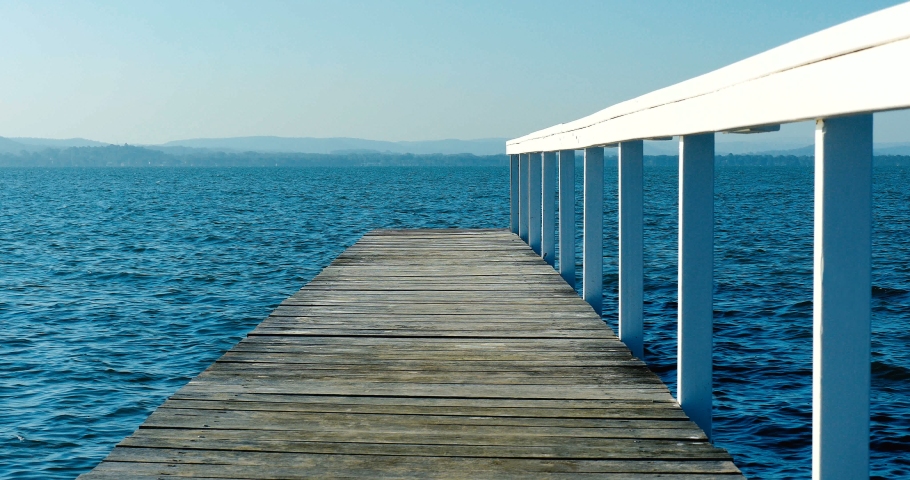 Waves swell under a beautiful jetty / pier / walkway over the sea. calm, restful.