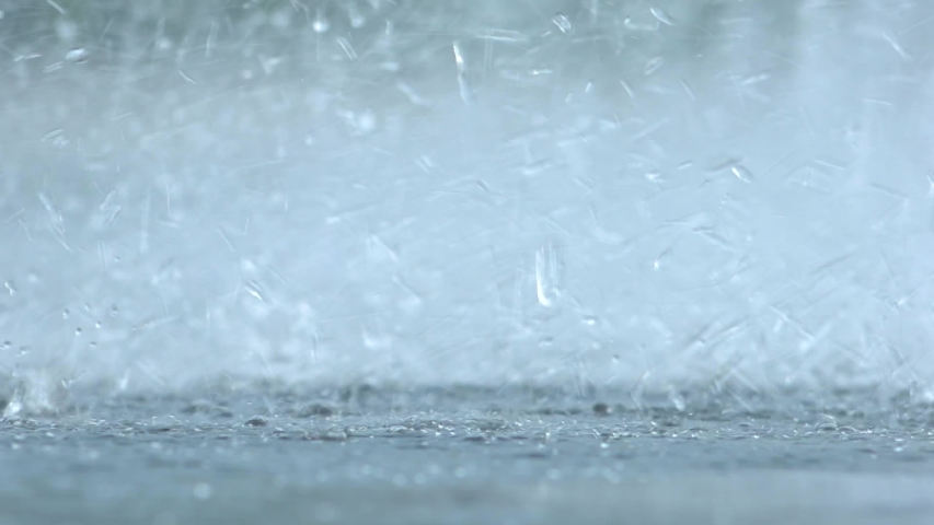 Rain splashes hit the asphalt, heavy rain, close-up Royalty-Free Stock Footage #1056215447