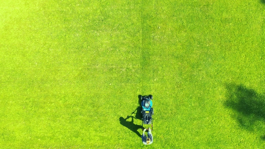 Woman cuts the lawn. Mowing lawns. Aerial view beautiful woman lawn mower on green grass. Mower grass equipment. Mowing gardener care work tool. Aerial lawn mowing | Shutterstock HD Video #1056217751