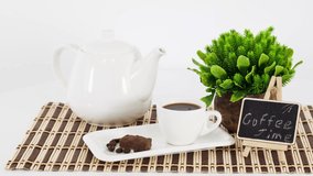 Coffee cup with kettle and cookies on wooden table background.