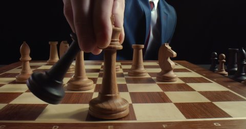 Close up of businessman moving white king defeating black king of opponent during chess game. Competition, leadership and checkmate concept