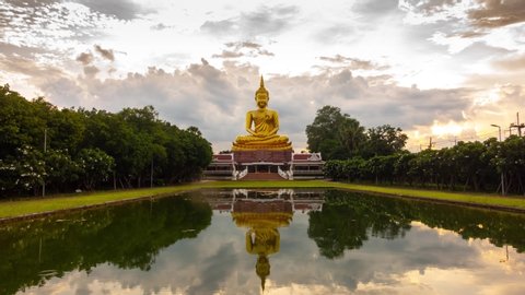 4K:Time lapse Beautiful  Big Golden Buddha statue against sunset clouds sky in Thailand temple,khueang nai District, Ubon Ratchathani province, Thailand.
